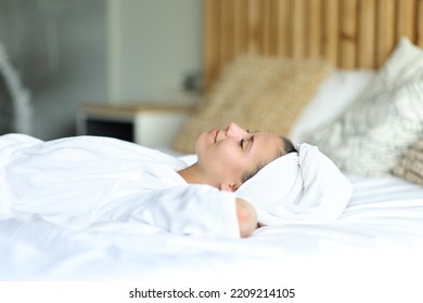 Happy woman resting lying on the bed after showering at home - Shutterstock ID 2209214105