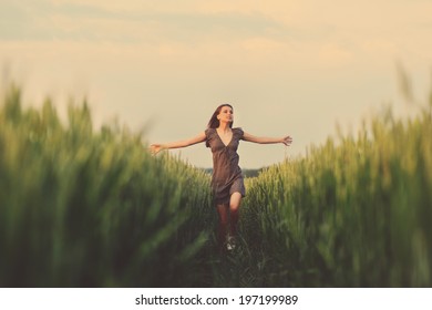 Happy Woman Running In The Green Field