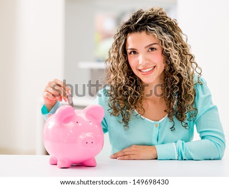 Happy woman saving money in a piggybank 