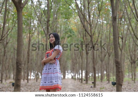 Happy woman She stands or walks in the rubber plantations in Thailand.