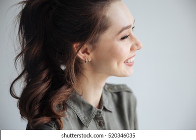 Happy Woman In Shirt In Profile. In Studio. Isolated Gray Background