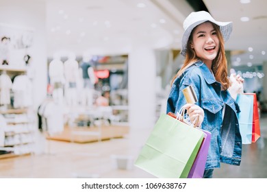 Happy Woman With Shopping Bags With Colourful And Creditcard With Cloth Shop Background - Shopping Credit Card Payment Concept