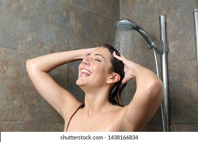 Happy woman showering and singing under a water jet at home
