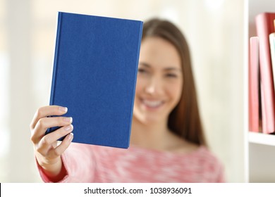 Happy Woman Showing A Blank Cover Of A Book At Home