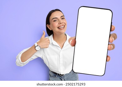 Happy woman showing mobile phone with blank screen on blue violet background. Mockup for design - Powered by Shutterstock