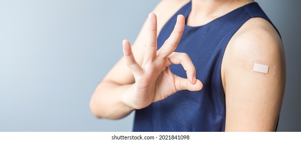 Happy woman showing OK sign with bandage after receiving covid 19 vaccine. Vaccination, herd immunity, side effect, efficiency, vaccine passport and Coronavirus pandemic - Shutterstock ID 2021841098