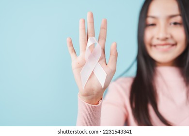 happy woman showing pink ribbon, Breast cancer awareness, world cancer day, national cancer survivor day in february concept.	 - Shutterstock ID 2231543341