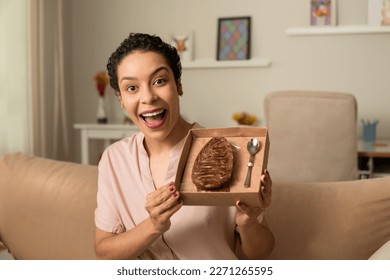 Happy woman showing stuffed chocolate easter egg at home. - Powered by Shutterstock