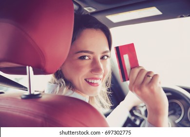 Happy Woman Sitting Inside Her New Car Showing Credit Card 