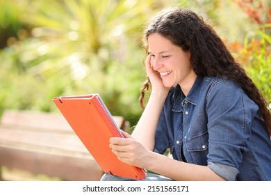 Happy woman sitting in a park studying reading paper notes