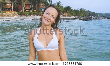 Happy woman smiling and having fun at beach. Summer portrait of young beautiful girl