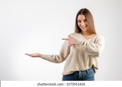 Happy Woman Smiling And Pointing Finger At Copy Space At Palm Of Hand Isolated Over White