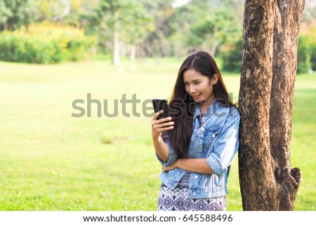 Happy woman speak and use smart phone outdoor