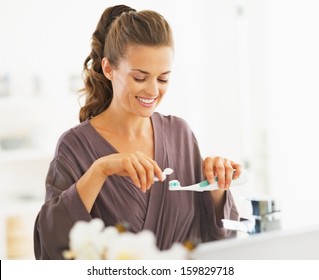 Happy Woman Squeezing Toothpaste From Tube