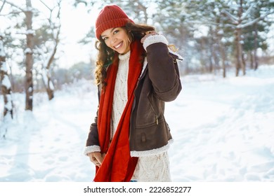 Happy woman standing among snowy trees and enjoying first snow. Holidays, rest, travel concept - Powered by Shutterstock