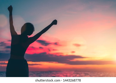 Happy woman standing arms outstretched back and enjoy life on the beach at Sea, background sky sunset silhouette. - Shutterstock ID 1443268778