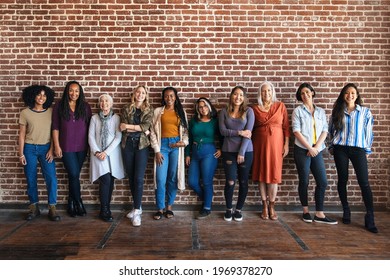 Happy woman standing by a brick wall  - Shutterstock ID 1969378270