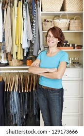 Happy Woman Standing In Front Of Custom Organized Closet At Home