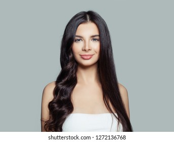Happy woman with straight hair and curly hair using hair straightener. Cute girl straightening healthy brunette hairstyle with flat iron. Hair care concept