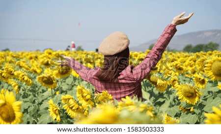 A happy woman in a sunflower garden blue sky