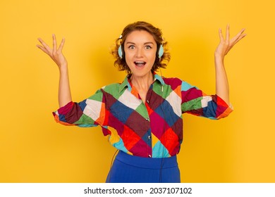 Happy Woman With  Suprice Face  Listenning Music By Earphones  And Having Fun Over Yellow Background. 