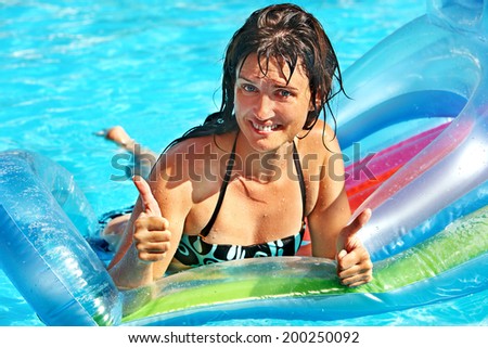 Happy woman  swimming on inflatable beach mattress.