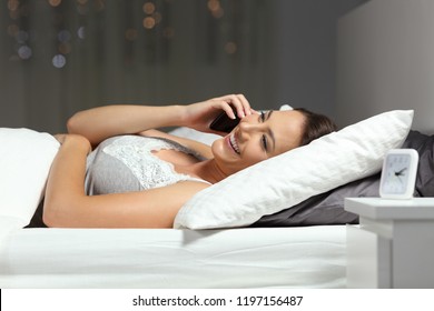 Happy Woman Talking On Phone In The Night In The Bed At Home