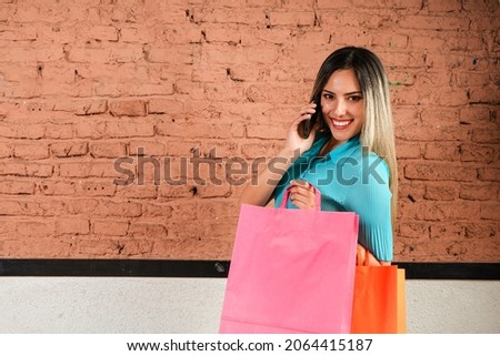 Happy woman talking on the phone with freshly made shopping bags. Copy Space