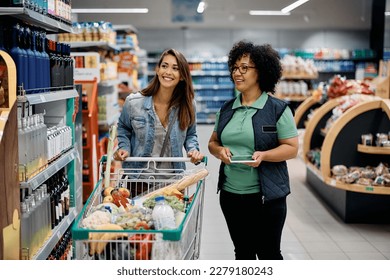 Happy woman talking to supermarket worker while buying at the store. - Powered by Shutterstock