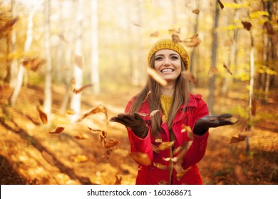 Happy Woman Throwing Leaves