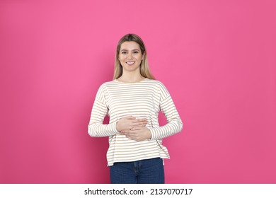 Happy Woman Touching Her Belly On Pink Background. Concept Of Healthy Stomach