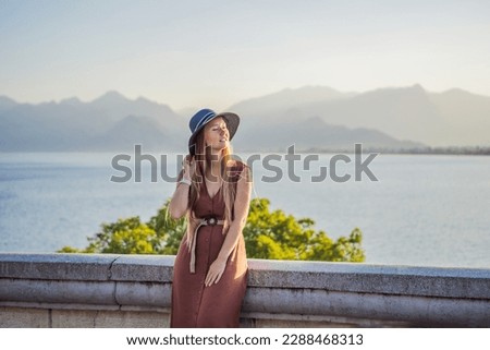 Happy woman tourist on background of Antalya sea and mountain views, sea in Turkey Antalya City. female tourist traveler discover interesting places and popular attractions and walks in the old city