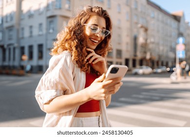 Happy woman tourist with phone. Young woman writing text for sharing content about vacations. Blogging, Lifestyle, travel, tourism, active life. - Powered by Shutterstock