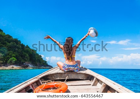 Happy woman traveler in bikini relaxing on boat her arms open feeling freedom, Andaman sea, Surin island, Phangnga,Travel in Thailand, Beautiful destination Asia, Summer holiday outdoors vacation trip