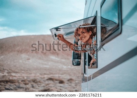 Happy woman traveler lifestyle opening camper van window and enjoying scenic parking outdoors landscape. Feeling of freedom. Alternative off grid tiny house people life. Vanlife travel independence.