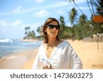 Happy woman traveller enjoying vacation on the beautiful tropical beach in paradise island in Sri Lanka. Freedom concept.