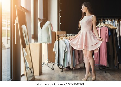 Happy woman trying on new dress in showroom. Fashion and choice concept - Powered by Shutterstock