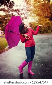 Happy Woman With Umbrella Checking For Rain In A Park