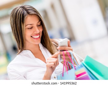 Happy Woman Using Cell Phone At A Shopping Center