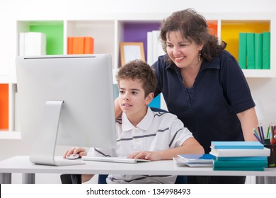 Happy Woman Using Computer With Son Looking  At Screen