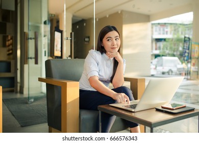 Happy woman using laptop in cafe - Shutterstock ID 666576343
