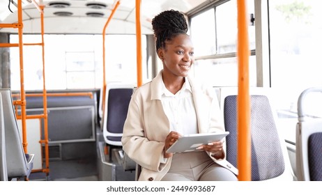 Happy woman using tablet while riding in a bus - Powered by Shutterstock