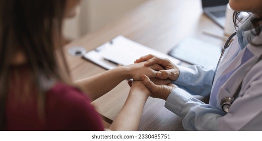 Happy woman visiting doctor senior , getting optimistic news after medical checkup, therapy. Therapist holding hand of patient, giving hope, support, congratulating on goor treatment result - Shutterstock ID 2330485751