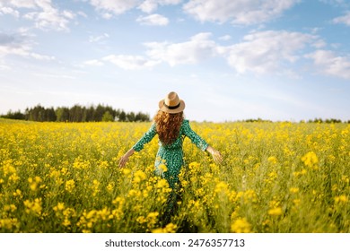 Happy woman walking in flowering field. Fashion, beauty concept. Summer landscape. - Powered by Shutterstock