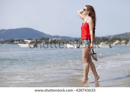 Happy woman walking on sandy beach, Laganas Zakynthos Greece