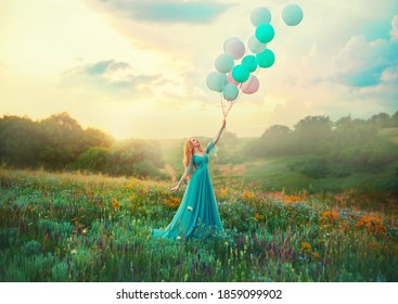 Happy woman walks in blooming valley. Fantasy girl princess holding in hand ball air balloon. long blue tulle fashion dress. Sunset sky, magic haze fog, flowers green meadow. blonde hair. Smiling face - Powered by Shutterstock