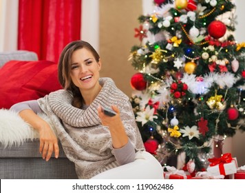 Happy Woman Watching TV Near Christmas Tree