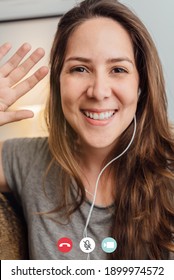 Happy Woman Waving On Video Call Meeting Conference With Mobile Phone Inside Home During Lockdown Isolation - Focus On Face