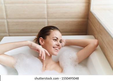 Happy Woman With Wet Hair Lies In The Bathroom White Foam Tile Fun