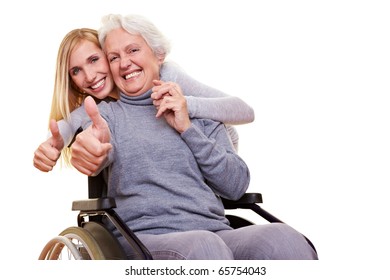 Happy woman in wheelchair with granddaughter holding her thumbs up